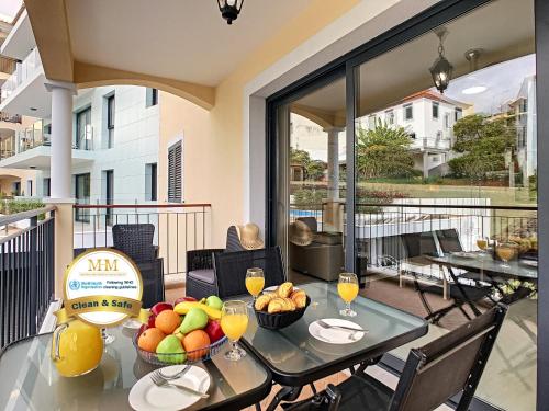 a table with fruit and wine glasses on a balcony at Apartment Lotus by LovelyStay in Funchal