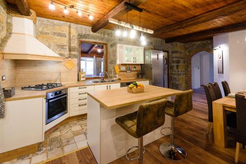 a kitchen with white cabinets and a wooden ceiling at The Hug of Nature in Dekani