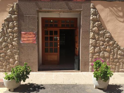 eine Tür zu einem Gebäude mit zwei Topfpflanzen in der Unterkunft Edificio Mirasierra in Oropesa del Mar