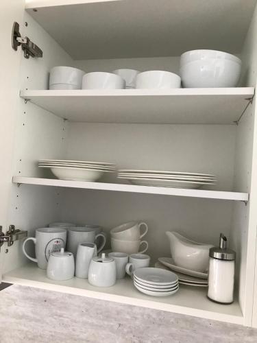 a cupboard filled with white dishes and plates at Isiliving in Montabaur
