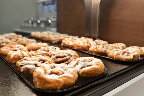 a bunch of donuts on trays in a display case at Holiday Inn Express Hotel & Suites Fort Myers East - The Forum by IHG in Fort Myers