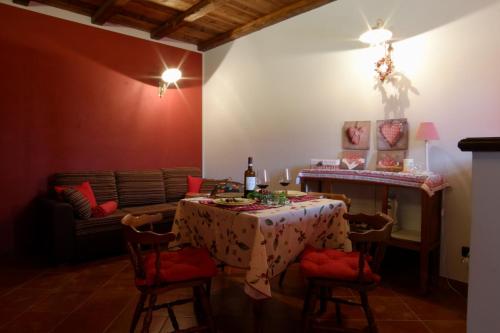 a dining room with a table and a couch at Tre colline in langa in Bubbio