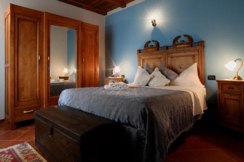 um quarto com uma cama grande e uma cabeceira em madeira em Tre colline in langa em Bubbio