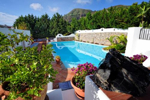 uitzicht op een zwembad met planten bij Gattopardo Park Hotel in Lipari