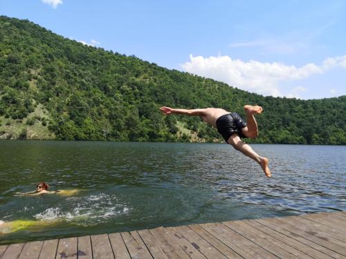 a man jumping off a dock into a lake at Nautica Bahna in Orşova