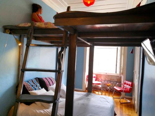 una camera da letto con due letti a castello con una bambina seduta sopra di Lisbon Calling a Lisbona