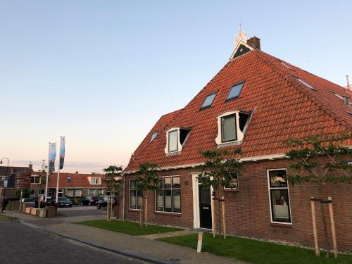 a brick building with a red roof on a street at Hotel Workum in Workum