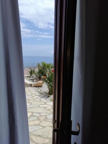 a view of the beach from an open door at Hotel Antica Cascina Del Golfo in Scopello