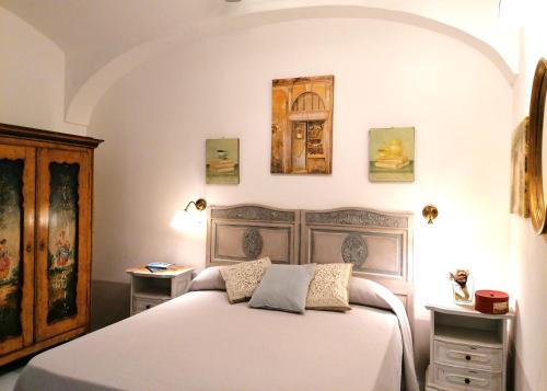 1 dormitorio con 1 cama y algunas fotos en la pared en La casa di Chloé, en Turín