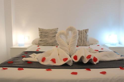 a bed with two swans made out of hearts at Luxury Hotel Suite Terrace & Parking in Málaga