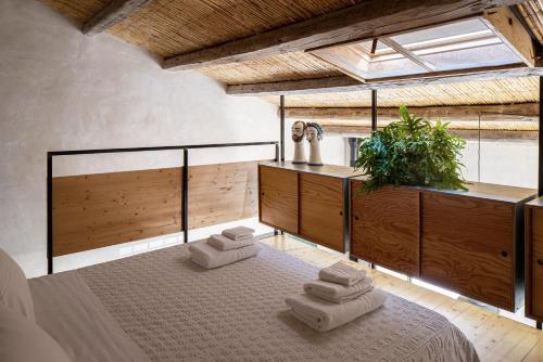 una camera da letto con un letto con quattro asciugamani di Casina Lanterne a Marina di Ragusa