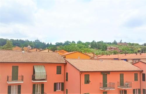 un grupo de edificios naranjas con árboles en el fondo en La Mansarda vicino alla stazione en Perugia