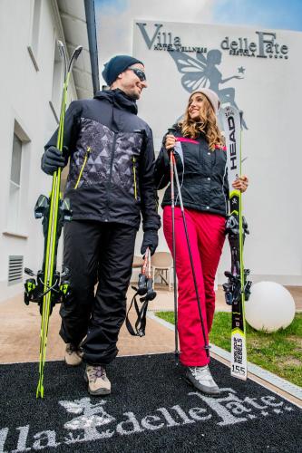 a man and a woman holding skis and poles at Hotel Villa delle Fate, BW Signature Collection in Sestola