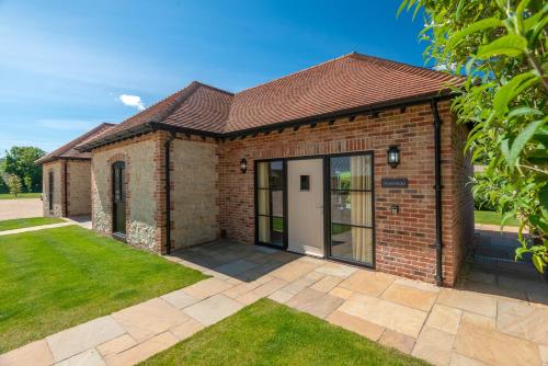 a brick house with a white door at Barrow Hill Barns in Petersfield