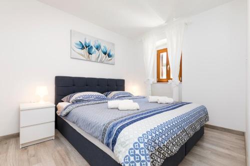una camera da letto con un grande letto con lenzuola blu e bianche di Vacation house Orange a Veli Lošinj (Lussingrande)