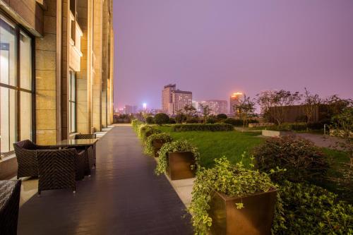 a walkway with benches and plants on a building at Crowne Plaza Hefei Rongqiao by IHG in Hefei
