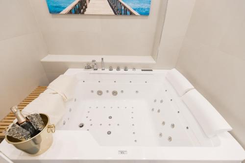 een wit bad in een badkamer met een foto van de oceaan bij MERGELLINA AMORE e FANTASIA in Napels