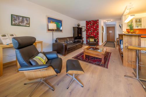 a living room with a couch and chairs and a table at Haus Sonnheim in Zermatt