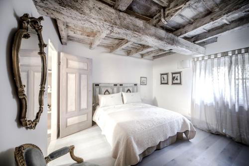 sypialnia z białym łóżkiem i otwartymi drzwiami w obiekcie La casa di Chloé w Turynie