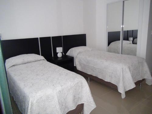 a bedroom with two beds and a mirror at Green Park Punta 2 in Punta del Este