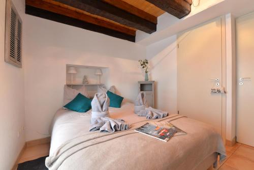 une chambre avec un grand lit avec des oreillers verts dans l'établissement Appartement Le cosy de la Petite Venise, à Colmar