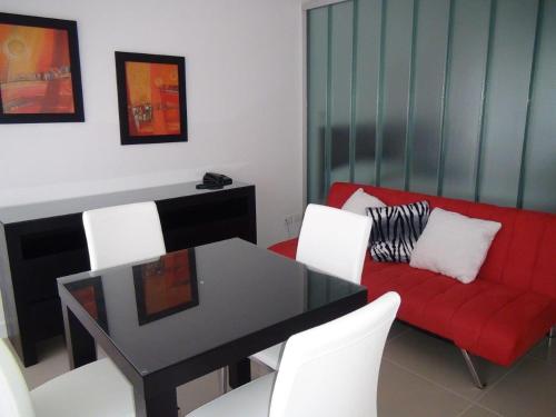 a living room with a table and a red couch at Green Park Punta 2 in Punta del Este