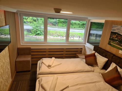 a bedroom with two beds and two windows at Helvetia in Seewen