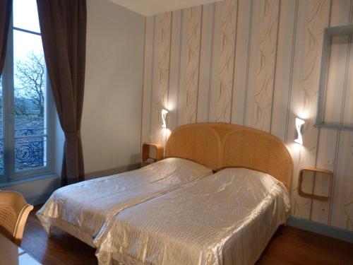 ein Schlafzimmer mit einem Bett mit zwei Leuchten in der Unterkunft Hôtel Restaurant du Cheval Blanc in Saint-Boil