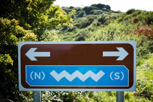 a brown and blue sign with arrows on a road at Joyce's Carndonagh Inishowen in Carndonagh