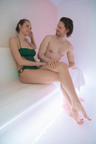 a man and a woman sitting on a bed at Hotel Villa delle Fate, BW Signature Collection in Sestola