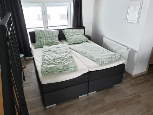 1 cama con sábanas y almohadas verdes en una habitación en Beim Hooch "Christ", en Brücktal