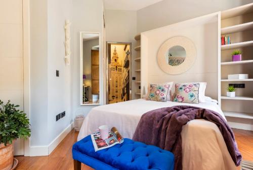 una camera con letto e sgabello blu di Cathedral Luxury Studio, Swimming Pool and Cathedral Views a Siviglia