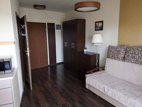 a living room with a couch and a door to a room at Foka, Sun & Snow in Hel