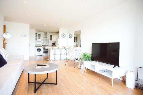 a living room with a large flat screen tv at Stunning Two Bed Sea View Apartment with Pool & Gym in Newquay