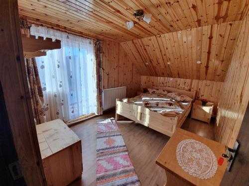 a room with two beds in a wooden room at Cabana Popasul Vânătorului in Arieşeni