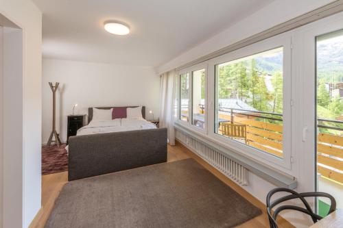 1 dormitorio con cama y ventana grande en Haus Sonnheim, en Zermatt