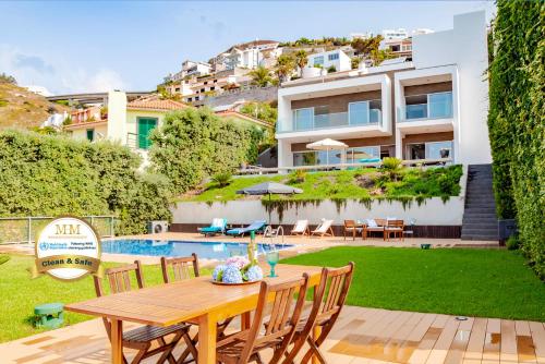 a patio with a table and chairs and a building at Villa Chimera By LovelyStay in Caniço