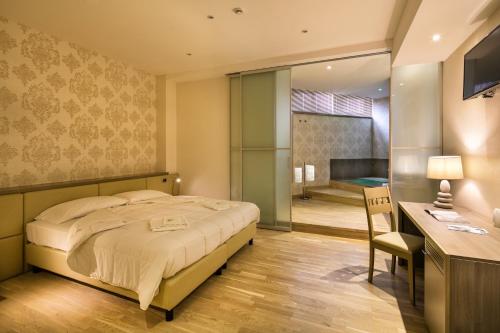 a bedroom with a large bed and a desk with a chair at Umbriaverde Sporting & Resort in Massa Martana