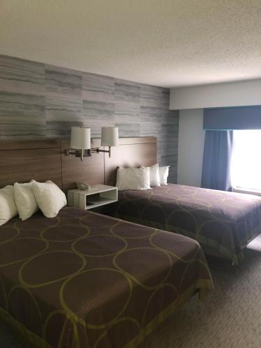 a hotel room with two beds and a window at Super 8 by Wyndham Manchester Airport in Manchester
