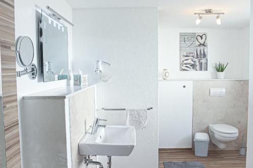 a white bathroom with a sink and a toilet at Bergkrönchen Winterberg - Sauna - 8Beds - outdoor in Winterberg