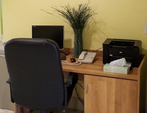 an office desk with a computer and a printer at Microtel Inn & Suites by Wyndham Delphos in Delphos