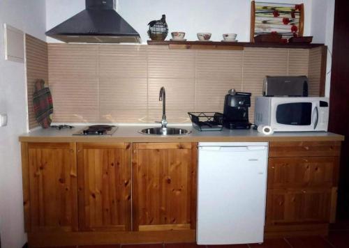 a kitchen with a sink and a microwave at Bungalow Beach in Brejao