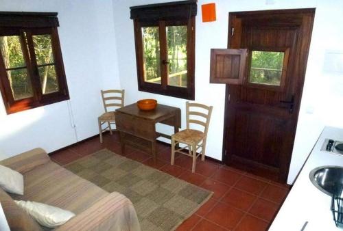 a bedroom with a bed and a table and a door at Bungalow Beach in Brejao