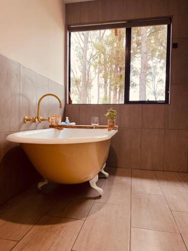a large tub in a bathroom with a window at Littlewood Chalet in Margaret River Town