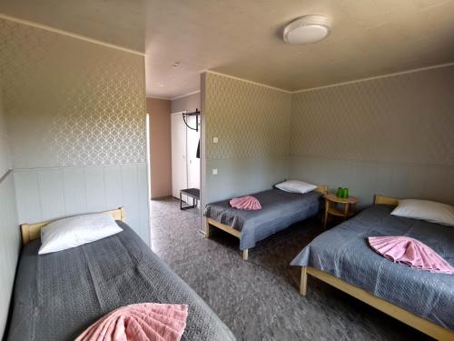 a bedroom with two beds and a table with a table at Kihnu Külalistemaja in Lemsi
