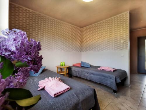 a room with two beds and purple flowers in it at Kihnu Külalistemaja in Lemsi