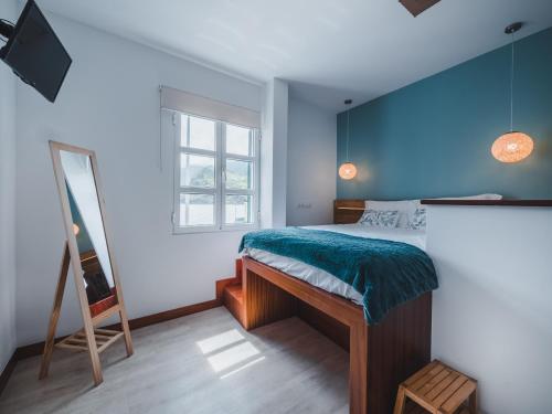 a bedroom with a bed with a blue wall at Nature Madeira Guest House in Porto da Cruz