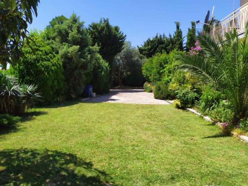 un jardín con césped verde, árboles y arbustos en Apartment Pletikos, en Premantura