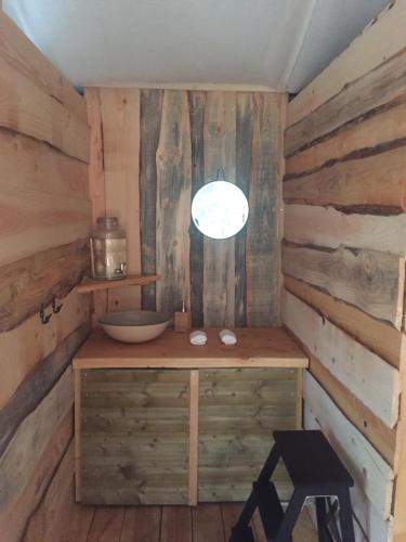 - une salle de bains avec lavabo dans une chambre dotée de murs en bois dans l'établissement cabane de l'Ecureuil, à Châtel-Guyon