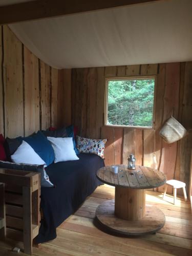 a room with a bed and a table and a window at cabane de l'Ecureuil in Châtel-Guyon